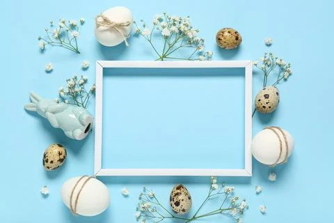 Photo frame with Easter eggs, ceramic bunny, gypsophila flowers and ribbon on Stock Photos
