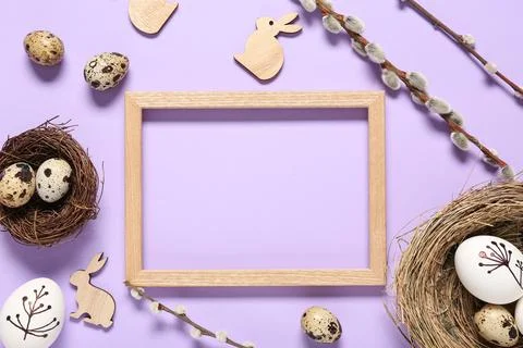 Photo frame with Easter eggs, pussy willow branches and decorative bunnies on Stock Photos