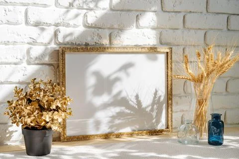Photo frames on a brick wall background on the table with wheat ears in vase Stock Photos