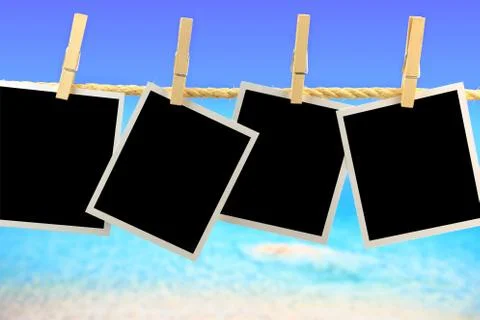 Photo frames hanging on a rope in front of the sea Stock Photos