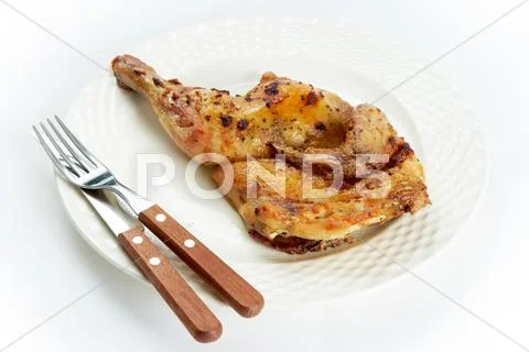 Photo of fried broiler lying on plate with fork and knife Stock-Fotos