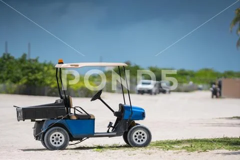 Photo of a golf cart on the beach shot with telephoto lens Stock Photos