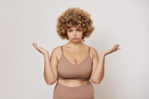 Photo of grumpy busty plus size female model keeps palms aside feels frustrated Foto stock