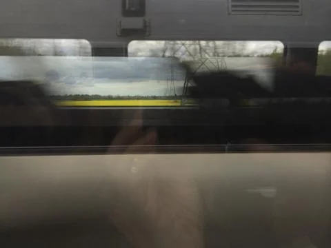 A photo of a hand, a camera, two reflections in windowpane of a speeding Train. Stock Photos