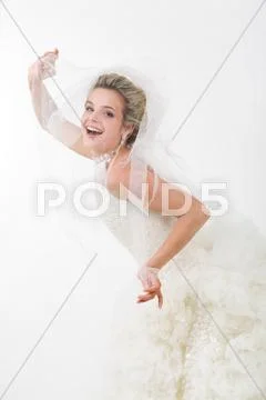 Photo of happy bride looking out of her veil and laughing at camera Stock Photos