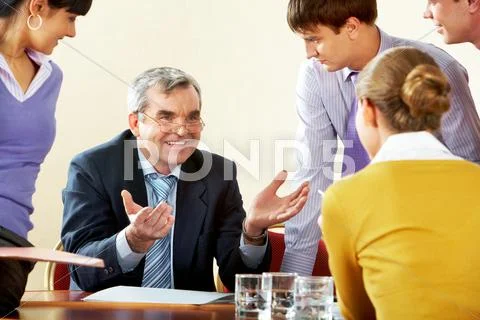 Photo of happy chief explaining work to subordinate persons Stock Photos