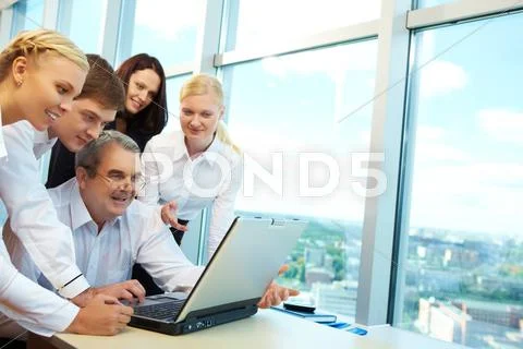 Photo of happy co-workers planning work while looking at laptop screen Stock Photos