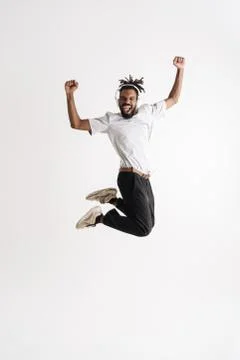 Photo of jumping while dancing african american guy in headphones jumping whi Stock Photos