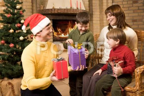 Photo of laughing family members with gifts in hands on christmas night Stock-Fotos