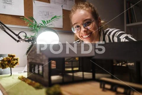 Photo of laughing professional woman architect draft with house model and sit Stock Photos