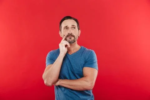 Photo of man 30s wih brooding gaze in casual t-shirt looking upward and think Stock Photos