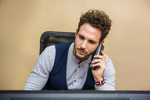 Photo of a man multitasking with a computer and a cell phone Stock-Fotos