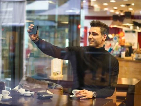 Photo of a man using a cellphone at a table Foto stock