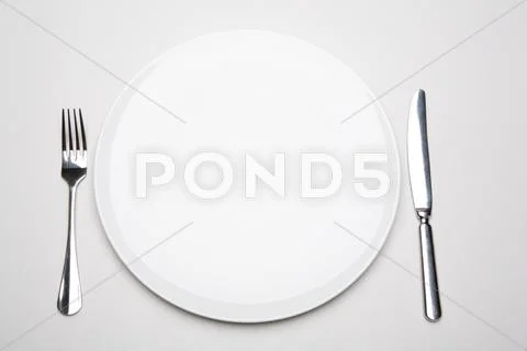 Photo of place in the restaurant: white empty plate with fork and knife near by Stock-Fotos