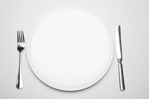 Photo of place in the restaurant: white empty plate with fork and knife near by Stock Photos