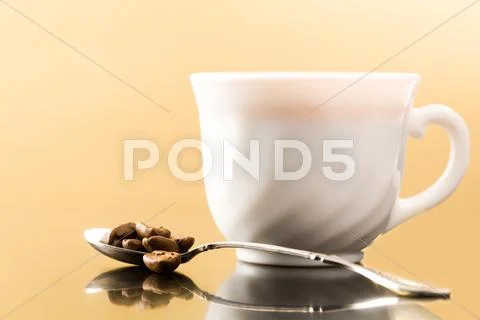 Photo of porcelain coffee cup with spoon full of coffee beans near by Stock Photos