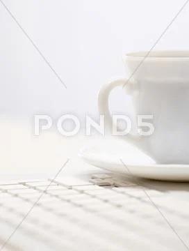 Photo of porcelain coffee cup on white keypad Stock Photos