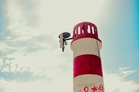 Photo of a red-white lighthouse against the sky Stock Photos