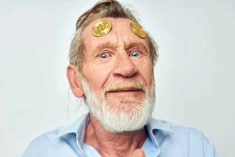 Photo of retired old man in a blue shirt bitcoins on the face isolated Stock Photos