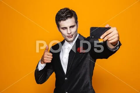 Photo of scary dead man on halloween wearing classical suit and creepy makeup Stock Photos