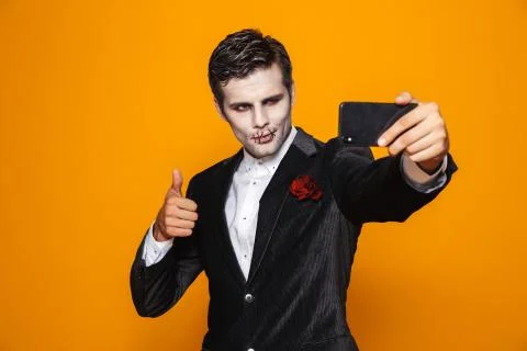 Photo of scary dead man on halloween wearing classical suit and creepy makeup Stock Photos