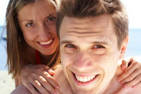 Photo of smiling guy looking at camera while pretty woman behind embracing him Stock Photos