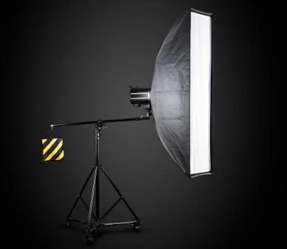 Photo studio lighting stands with flash and softbox isolated on the black. Stock Photos