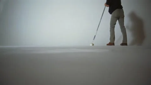 A photo studio worker paints the surface of a cyclorama with white paint Stock Footage 337118378