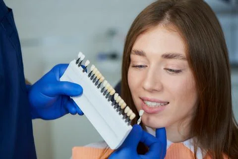 Photo of a teeth shade sample that matching to a female patient in dental cha Stock Photos