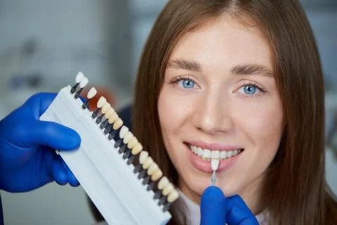 Photo of a teeth shade sample that matching to a female patient in dental cha Stock Photos