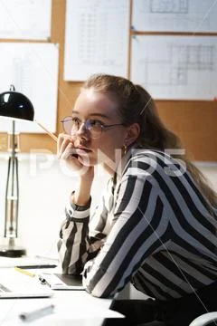 Photo of thinking european woman architect wearing glasses designing draft an Stock Photos