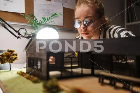Photo of thoughtful professional woman architect designing draft with house m Stock Photos