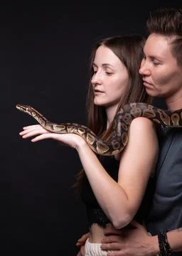 Photo of two hugging women with python on shoulders Stock-Fotos