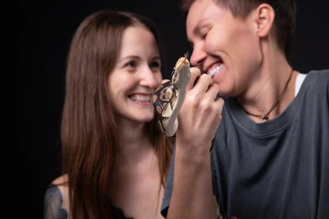 Photo of two women with python on black background Stock-Fotos