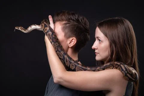 Photo of two women with python on closed eyes in profile Stock Photos