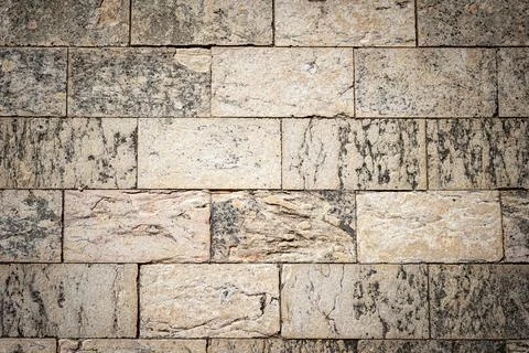 Photo of a wall made of roughly processed stone bricks Foto stock