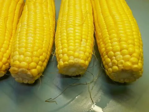 Photo of yellow corn kernels on a table, photographed from above. Stock Photos