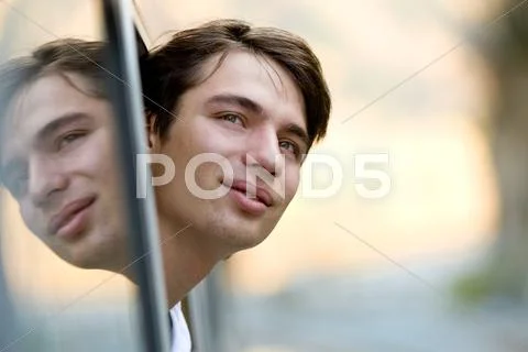 Photo of young commuter looking out of train window during journey Stock-Fotos