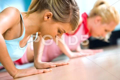 Photo of young girl doing difficult exercise for arm biceps on the floor Stock Photos