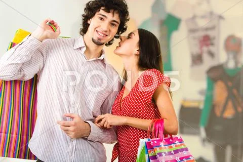 Photo of young woman whispering something to her boyfriend in the trade center Stock Photos