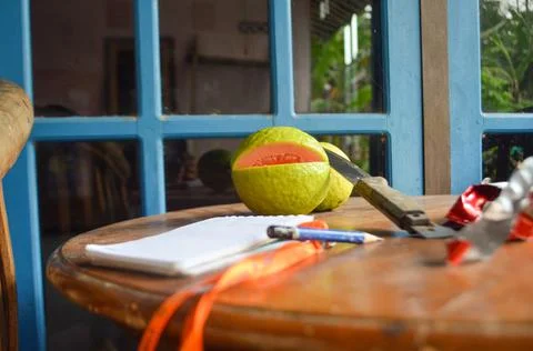 Photograph of several objects such as guava, pencil, knife, notebook on a woo Stock Photos