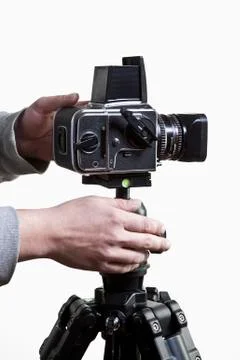 A photographer adjusting a medium format camera on a tripod, close-up of hands Stock Photos