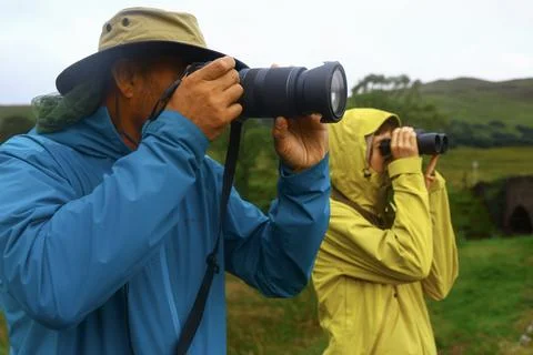 Photographer and observer using camera and binoculars in Scottish Highlands Photos