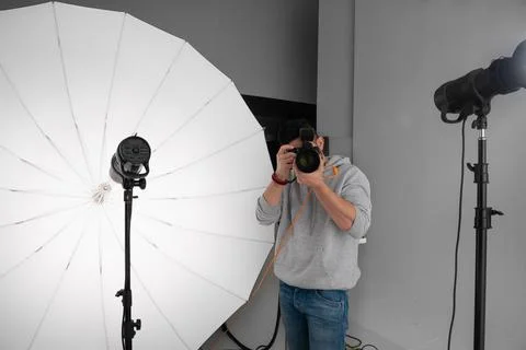 Photographer with camera in hand in studio.Concept Stock Photos