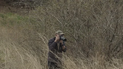 Photographer with camera in marsh, 2k Stock Footage 153699176