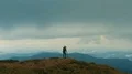 The photographer with a camera standing on the mountain top 4k or 4k+ Resolution