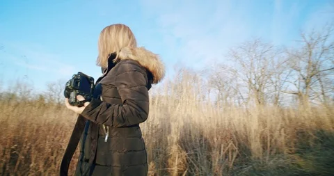 Photographer With Camera Walks Through Field Stock Footage 122221226
