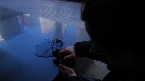 Photographer capturing creative water shot on granite ledge 1 스톡 동영상 87708995