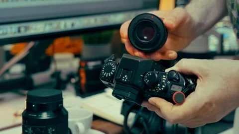 Photographer changing camera lens professional photo studio equipment Stock Footage 336099537