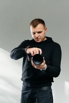Photographer Checking Camera Lens in Studio, Professional Photography Concept Stock Photos
